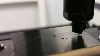 Scratch Adhesion Test Using Blade on Coated Surface Blade scratch adhesion test on black coated sample surface showing scratch marks
