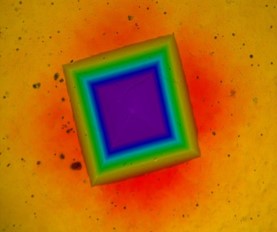 Hot Hardness Indentation at 450°C – Mid-Range Temperature Hardness Evaluation Optical microscopy image of Vickers hardness indent at 450 degrees Celsius with interference color stress pattern
